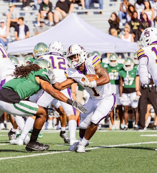 Eagle running back GeiVonni Washington tries to push off a tackle from a Dragon defender.